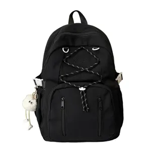Detailed view of the black canvas school backpack with front drawstring and cute plush pendant.