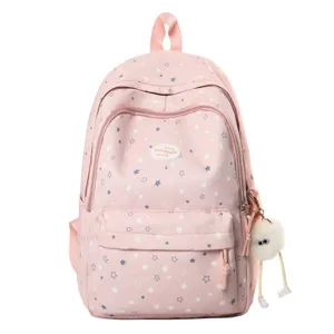 Vue de détail du sac à dos rose à motif d'étoiles, cartable mignon avec pendentif en peluche.