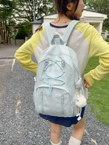 Japanese minimalist large capacity drawstring student backpack in light blue worn by model outdoors