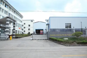 Vue extérieure de l'usine montrant le bâtiment de l'entreprise et la porte d'entrée sécurisée.