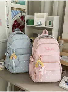 Close-up of pastel school backpack with star print, multi-compartments, and cute plush pendant.