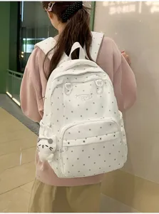 Vue détaillée d'un joli sac à dos blanc à pois avec un pendentif chat en peluche et logo.