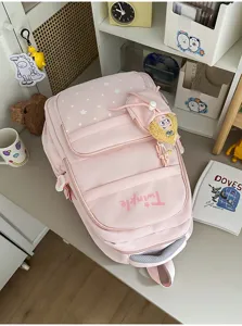 Pink star print school backpack detail, multi-compartment student bookbag with plush toy.