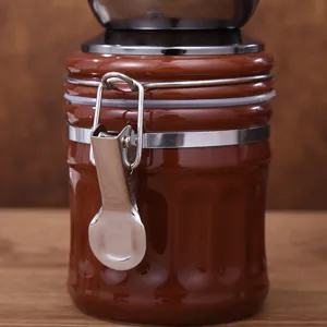 Portable manual ceramic coffee grinder detail view with metal latch and airtight seal mechanism.
