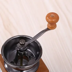 Nahaufnahme Detail der manuellen Vintage Kaffeemuehle Handkurbel und Metalltrichter.