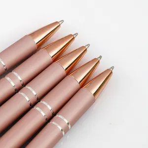 Pink rose gold metal ballpoint pens set, elegant writing instrument stationery detail view.