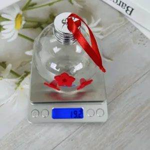 Comedero de colibrí de vidrio portátil con flores rojas y cinta colgante para jardín.