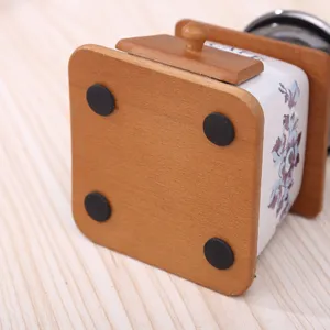 Vintage manuelle Kaffeemühle Detailansicht mit Holzbasis und Keramik Blumenmuster.