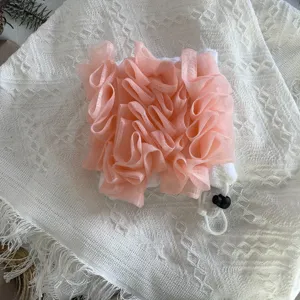 Gedetailleerd overzicht van de roze en witte 2-in-1 badspons en washandje voor reizen.