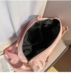 Vista detallada del interior de la gran bolsa de viaje rosa con múltiples compartimentos.