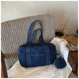 Vintage washed denim shoulder tote bag detail showcasing dual top handles and matching coin pouch.