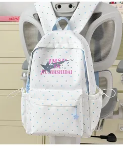 White blue polka dot backpack detail showing star print and front pocket design for students.