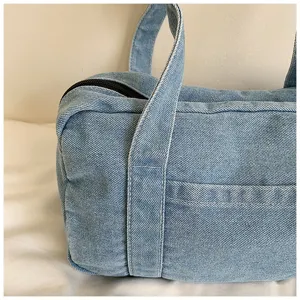 Detailed close-up view of the vintage washed blue denim shoulder bag handle design.