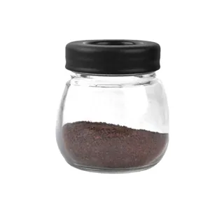 Transparante glazen voorraadpot met zwarte deksel en gemalen koffie voor thuis.