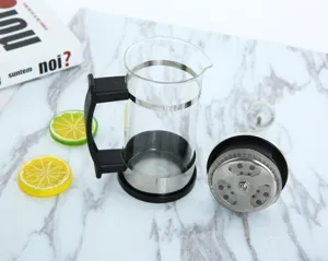 French press koffiezetapparaat detail met glazen houder en roestvrijstalen filterstempel.