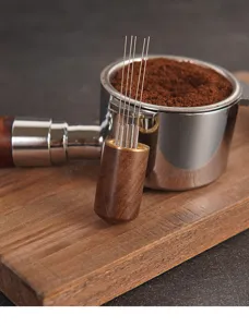 Vista di dettaglio dell'ago distributore di caffe in acciaio inossidabile con manico in legno.