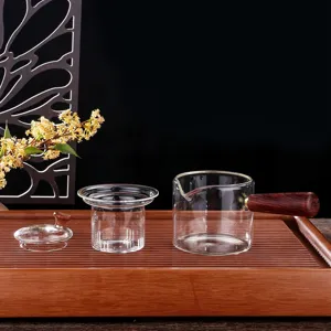 Clear glass tea maker set with wooden handle and infuser filter for brewing tea elegantly