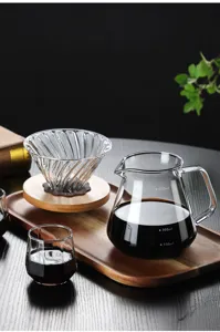 Detailed view of heat-resistant glass pour-over coffee maker set with wooden tray and clear scale.