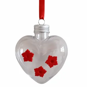 Clear heart-shaped hummingbird feeder with red ribbon and flower feeding ports for garden.