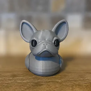 Detailed view of a 3D printed grey French bulldog duck figurine, creative desktop decor.