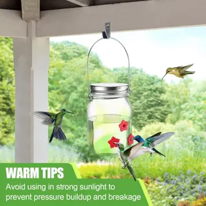 Close-up of hummingbirds at a hanging glass jar feeder with red flower ports in a garden