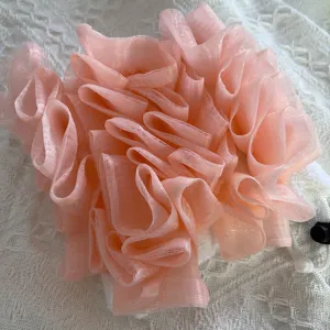 Roze badspons gecombineerd met een witte washand voor een milde dagelijkse lichaamspeeling.
