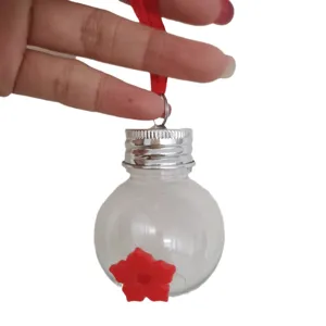 Handheld transparent plastic hummingbird feeder with a bulb-shaped bottle and red flower feeding port.