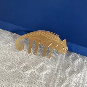 Vue détaillée de marque-page caméléon en métal doré, gros plan de déco animale créative.