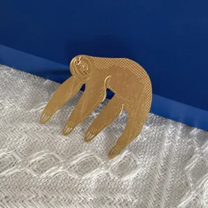 Vue de détail de l'ornement suspendu paresseux en métal doré avec un joli motif texturé.