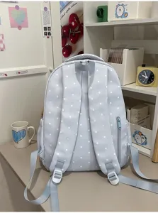 Vue détaillée du sac à dos d'écolier bleu clair à pois avec bretelles et fermeture éclair.