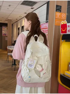 Detailansicht des Canvas-Schulrucksacks mit klarem Herzfenster und niedlichem Hasen-Plüsch.