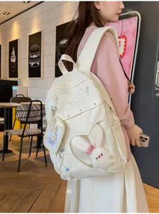 Schicker weißer College Rucksack mit Herz Fenster und süßem Plüschhasen Anhänger.