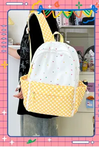 Detaillierte Ansicht des weißen Rucksacks mit bunten Punkten und gelben Karomustern im Detail.