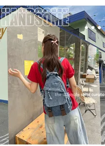 Detailopname van een vintage gewassen denim rugzak die het veelzijdige ontwerp laat zien.