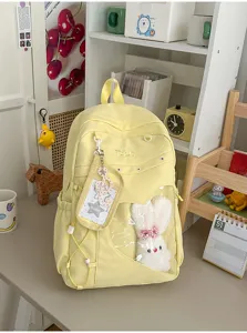Süßer gelber College-Leinwand-Schulrucksack mit klarem Frontfenster und Plüschhase.