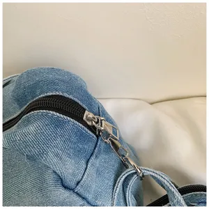 Detail view of blue denim shoulder bag zipper and metal hardware, casual everyday use.