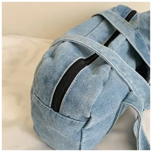 Detailed view of vintage washed denim shoulder bag, casual everyday commuter tote with zipper.