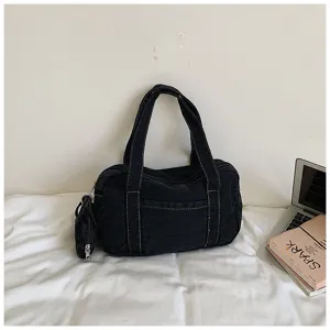Close-up detail of vintage washed denim shoulder bag, casual everyday underarm tote design.