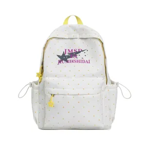 Detailed view of white student backpack with yellow polka dots, front pocket and letter print.