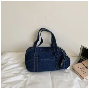 Detailed view of dark blue washed denim commuter tote bag, casual style with small hanging pouch.