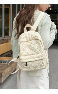 Close-up of beige quilted backpack on model, showing campus style and daily commuting details.