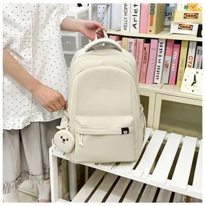 Vista dettagliata dello zaino scolastico in nylon bianco crema con ciondolo e tasca.