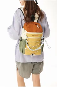 Close-up detail of multi-pocket color-block backpack, showing adjustable straps and cords.