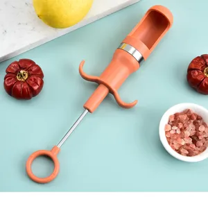 Vue détaillée de l'outil dénoyauteur orange avec tige métallique sur surface bleue de cuisine.