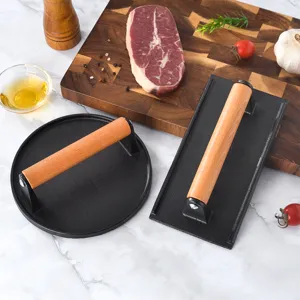 Cast iron burger press and grill weight with wooden handle for steak and BBQ cooking.