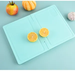 Detailed close-up view of the light green folding plastic cutting board in a fresh scene.