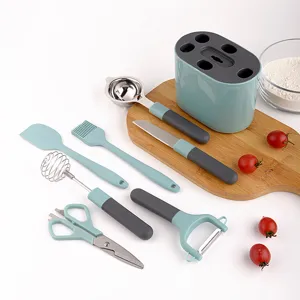 Juego de utensilios de cocina con cuchillas de acero inoxidable, espátula de silicona y soporte.
