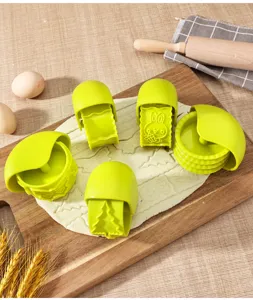 Green plastic baking pastry cutter set, biscuit mold and dough roller for kitchen use.
