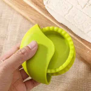 Green plastic pastry wheel cutter and dough press tool for biscuits and pizza.