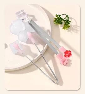 Detailed close-up view of stainless steel ice tongs featuring pink silicone cat paw grips.